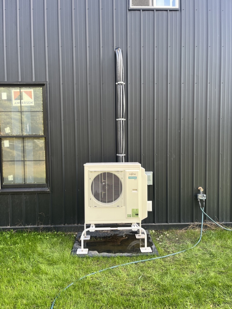 Ductless mini-split condenser mounted outside a West Michigan home